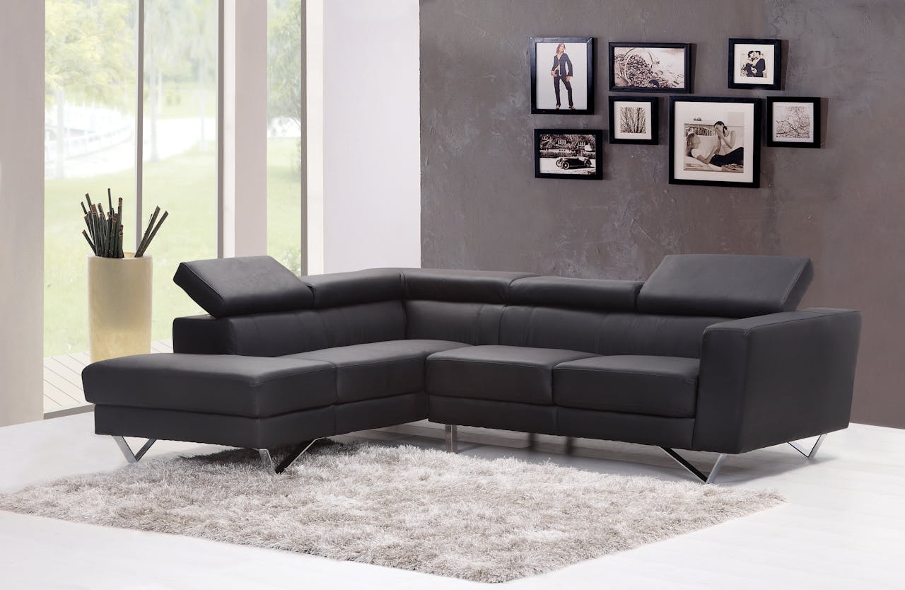 gallery-06 Contemporary living room featuring a sleek black sectional sofa and chic wall art.